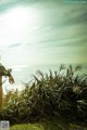 A woman standing in a grassy field next to the ocean.