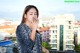 A woman standing on a balcony smoking a cigarette.