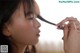 A woman is combing her hair with a brush.