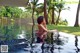 A woman in a pink bikini sitting in a swimming pool.