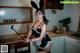 A woman in a bunny costume holding a spatula in a kitchen.