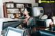 A woman is making coffee in a coffee shop.