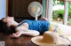 A woman laying on a table next to a fan.